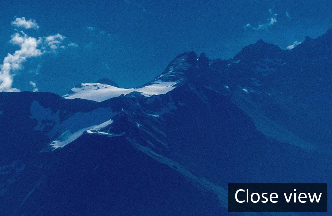 Close view of Serene Blue Mountain Landscape Mural Wallpaper featuring peaceful snowy peaks and sky.