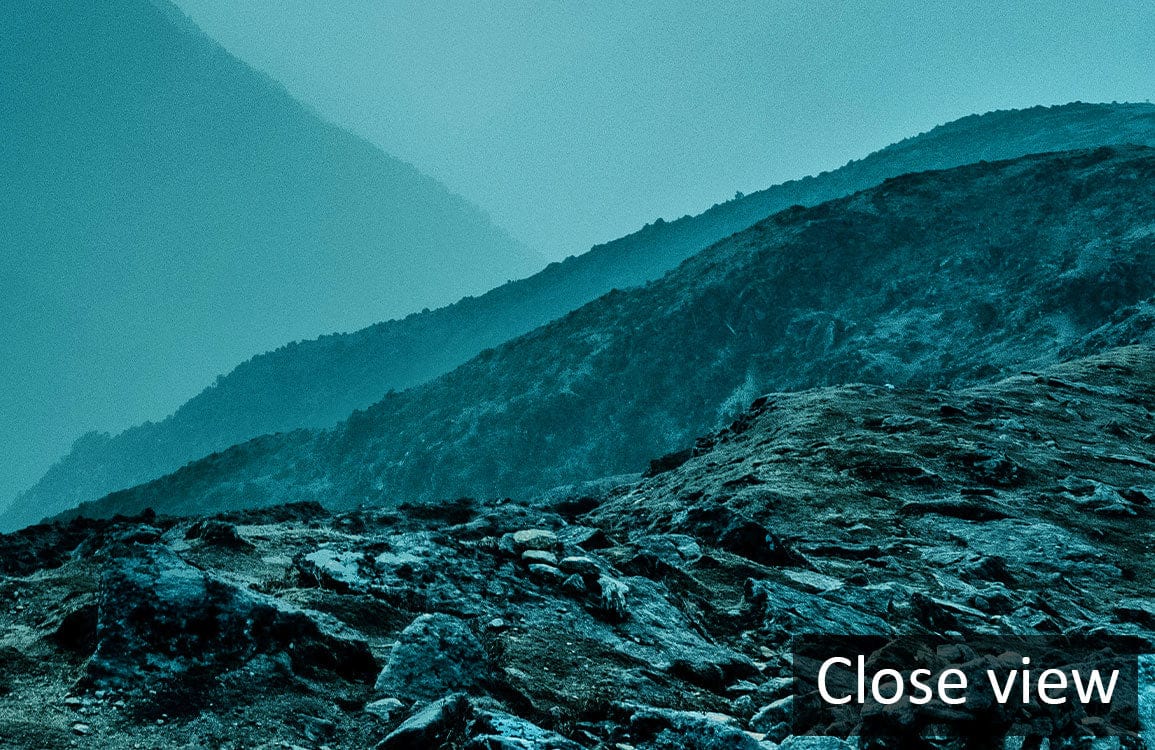 Serene Mountain Sunrise Mural Wallpaper in Tranquil Blue Tones, close-up view of textured landscape.