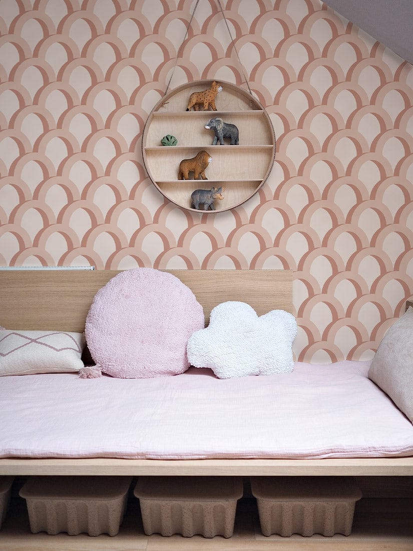 Elegant Peach Scales Wallpaper in nursery with wooden shelf, pink bedding, soft cushions, minimalist style.