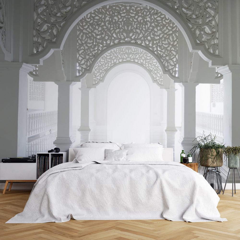 Ornate white archway mural in elegant bedroom with herringbone flooring, white bedding, and minimalist furniture.