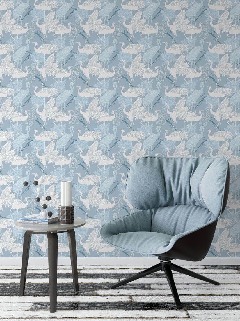 Sky Blue Origami Cranes Wallpaper in modern room with blue armchair, wooden flooring, side table.