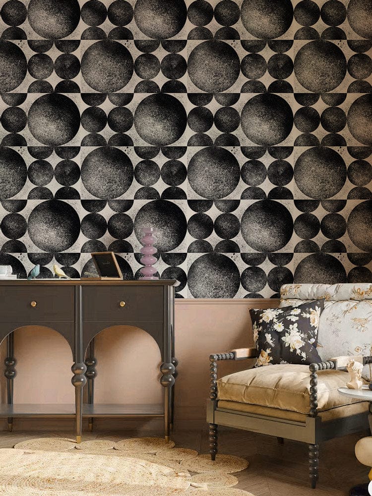 Monochrome geometric wallpaper, black console table, floral armchair, modern living room, wooden flooring.