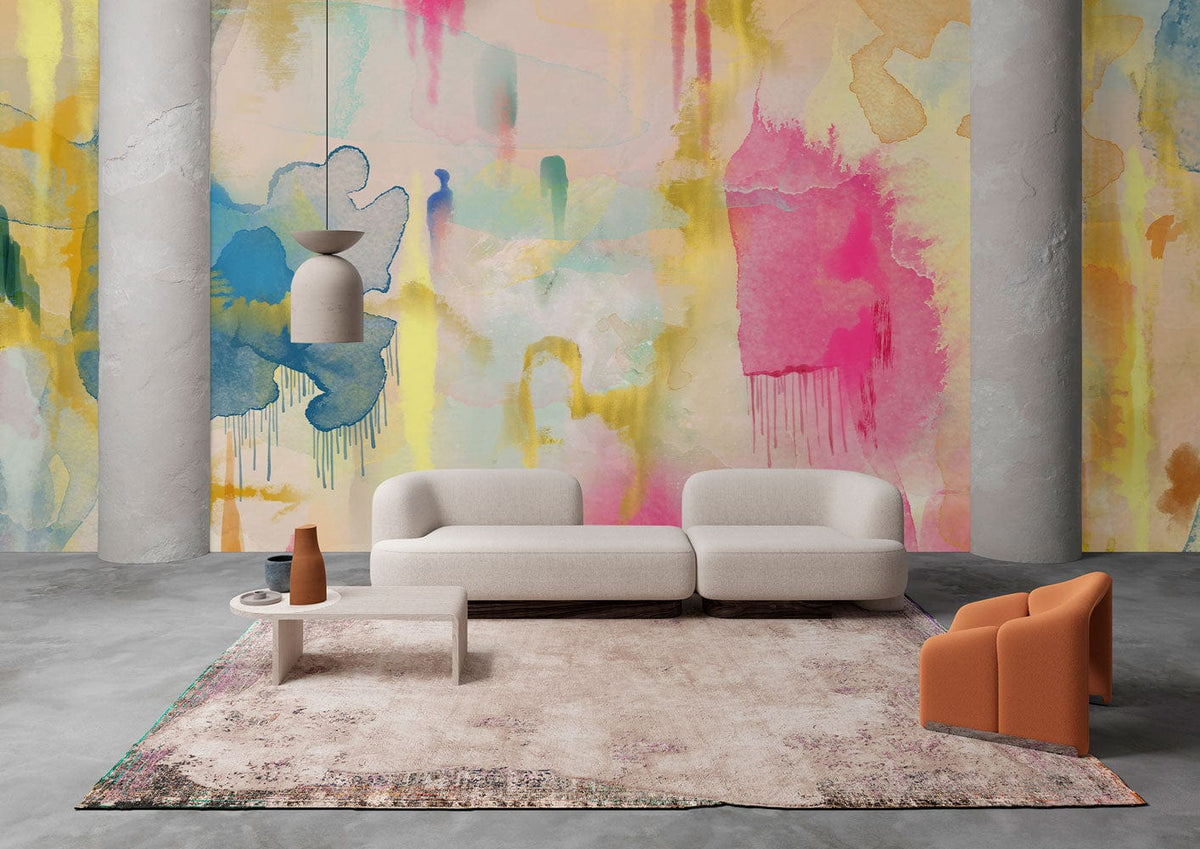 Vibrant watercolour mural wallpaper with colourful splashes, grey sofa, orange chair, concrete floor, modern room.