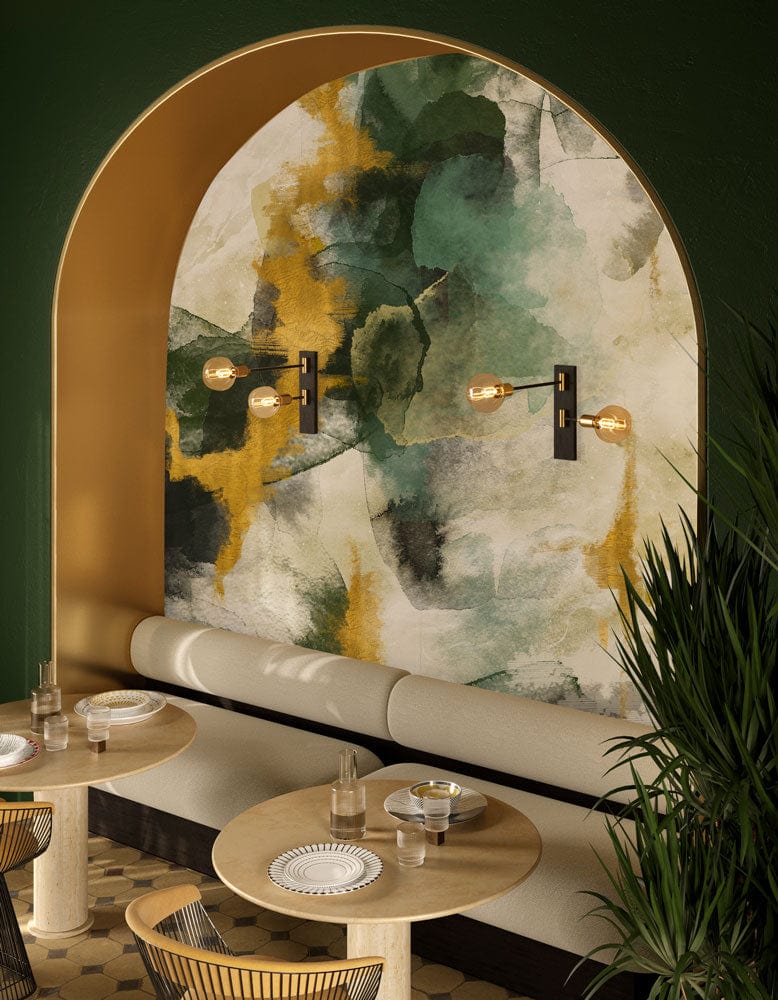 Abstract watercolour mural wallpaper in earthy greens and gold hues, with beige seating and round tables.