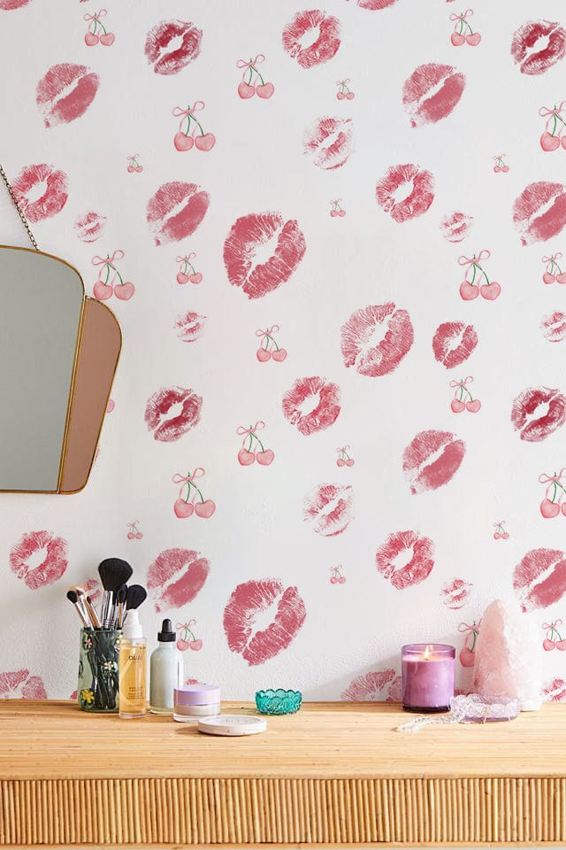 Red and white kiss print wallpaper, wooden dresser with mirror, stylish bedroom or makeup room decor.