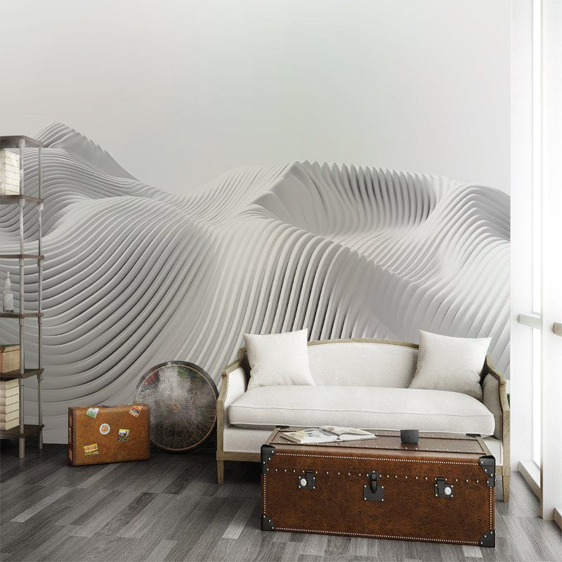 Elegant white 3D wave wallpaper in modern interior with grey sofa, wooden shelves, and dark flooring.