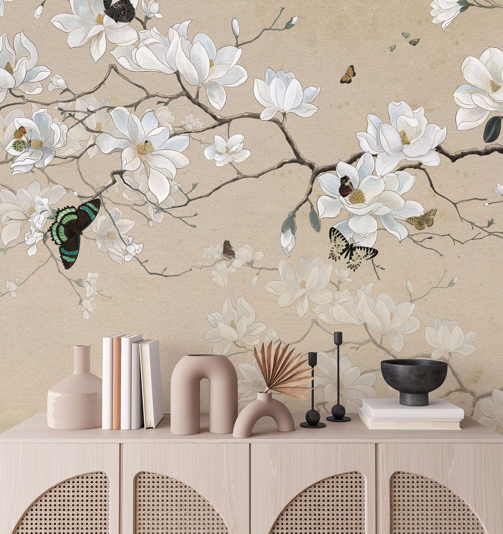 Elegant Beige Magnolia and Butterfly Floral Mural Wallpaper on Neutral Textured Wall Above Wooden Sideboard.