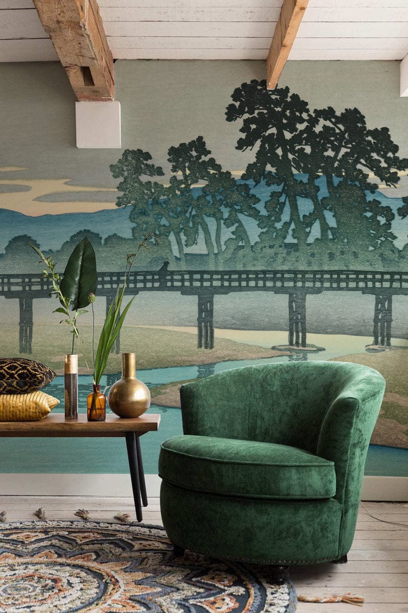 Serene Japanese Landscape Mural, green armchair, wooden coffee table, decorative rug, loft-style beams.