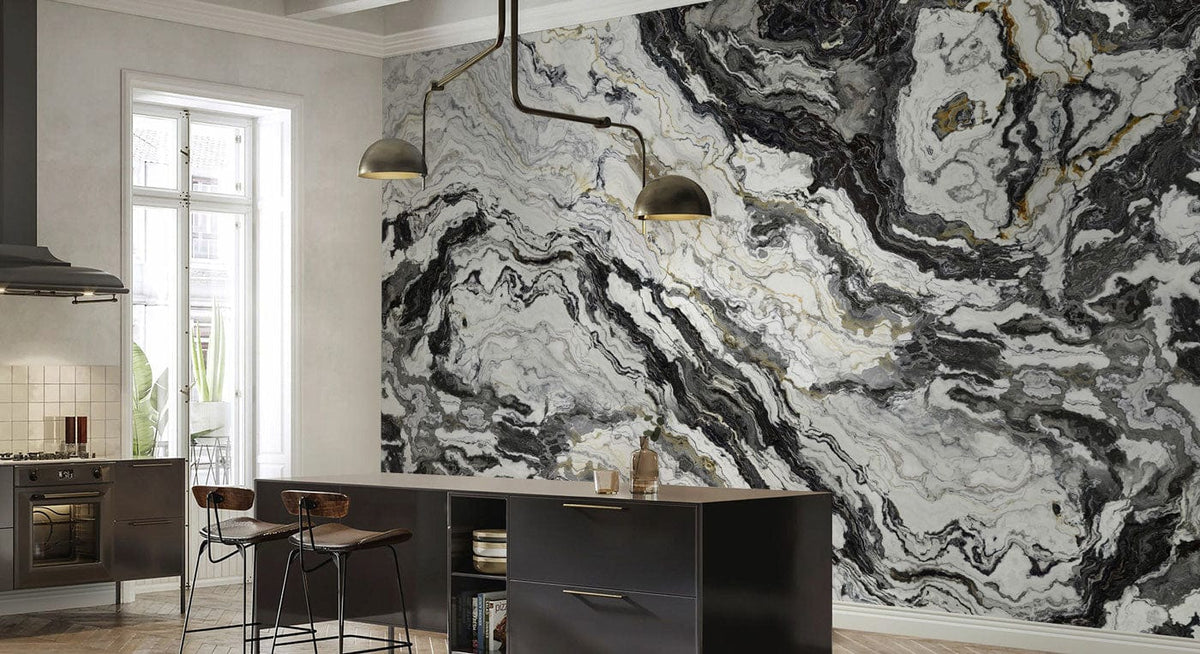 Modern monochrome marbled wallpaper in kitchen with grey cabinets, marble counter, and industrial lighting.
