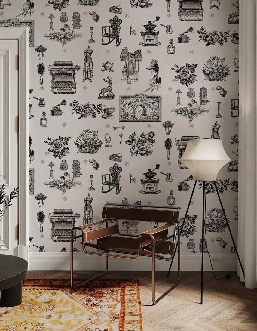 Vintage monochrome toile pattern wallpaper in stylish living room with brown chair, lamp, parquet flooring.