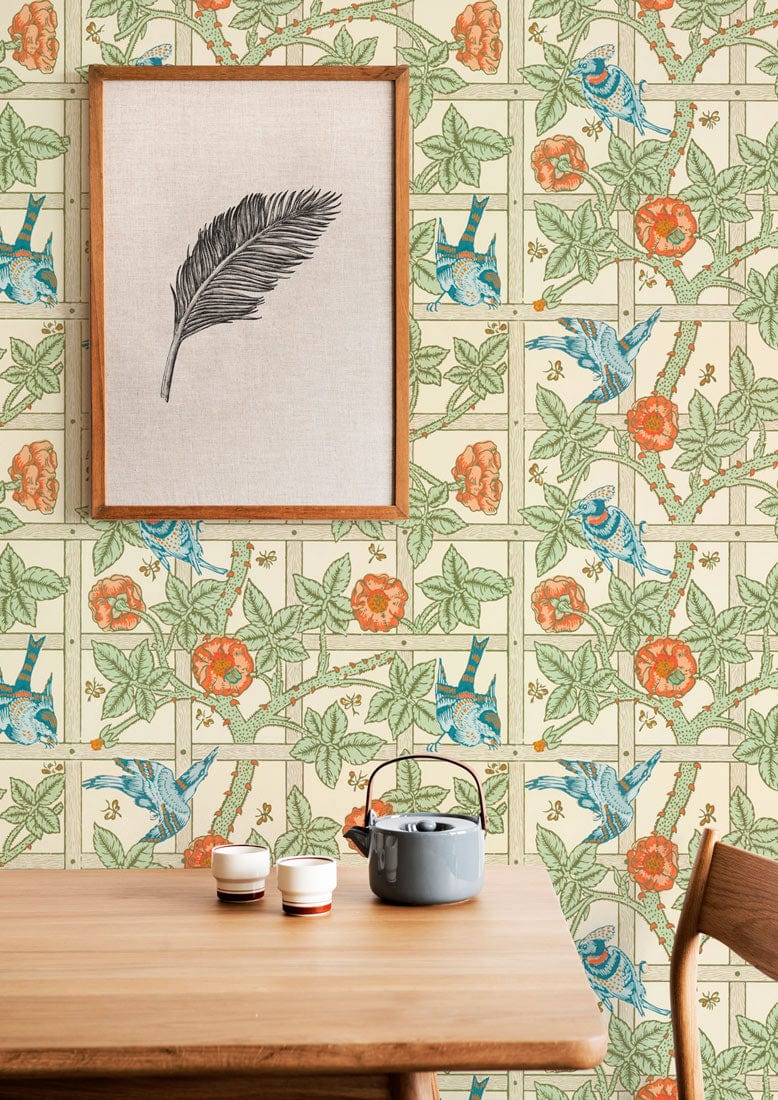 Vintage Botanical Garden Wallpaper in floral green and orange, wooden table, framed artwork, kitchen setting.