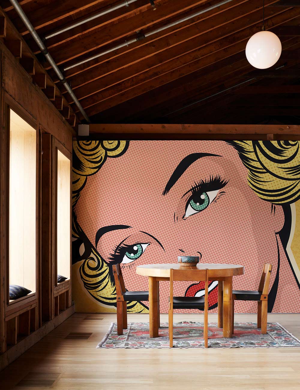 Pop Art Retro wallpaper featuring comic theme, set in wooden room with vintage dining table and rug.