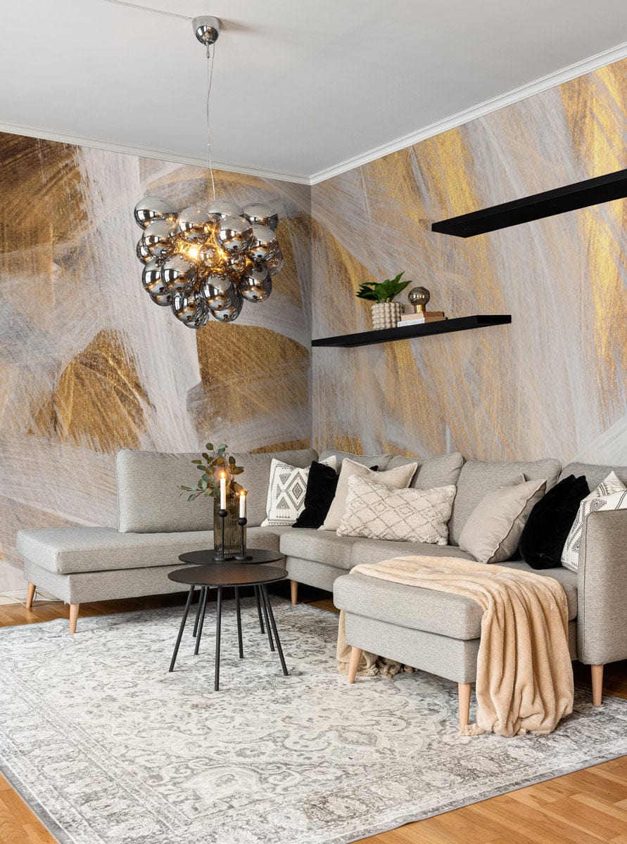 Elegant gold and white mural wallpaper in contemporary living room with grey sofa and wooden flooring.