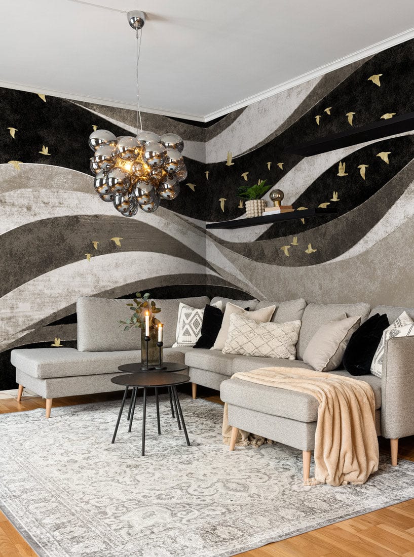 Grey sofa, monochrome wallpaper with gold accents in living room, stylish chandelier, wooden flooring.