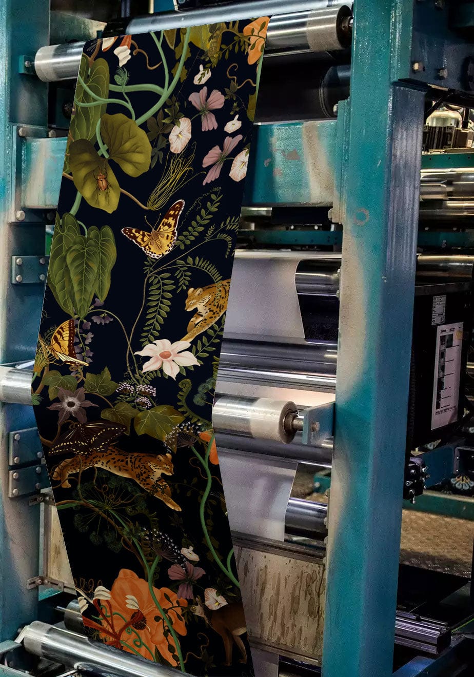 Wallpaper manufacturing machine displaying Luxury Botanical Jungle Mural with green and gold accents in progress.