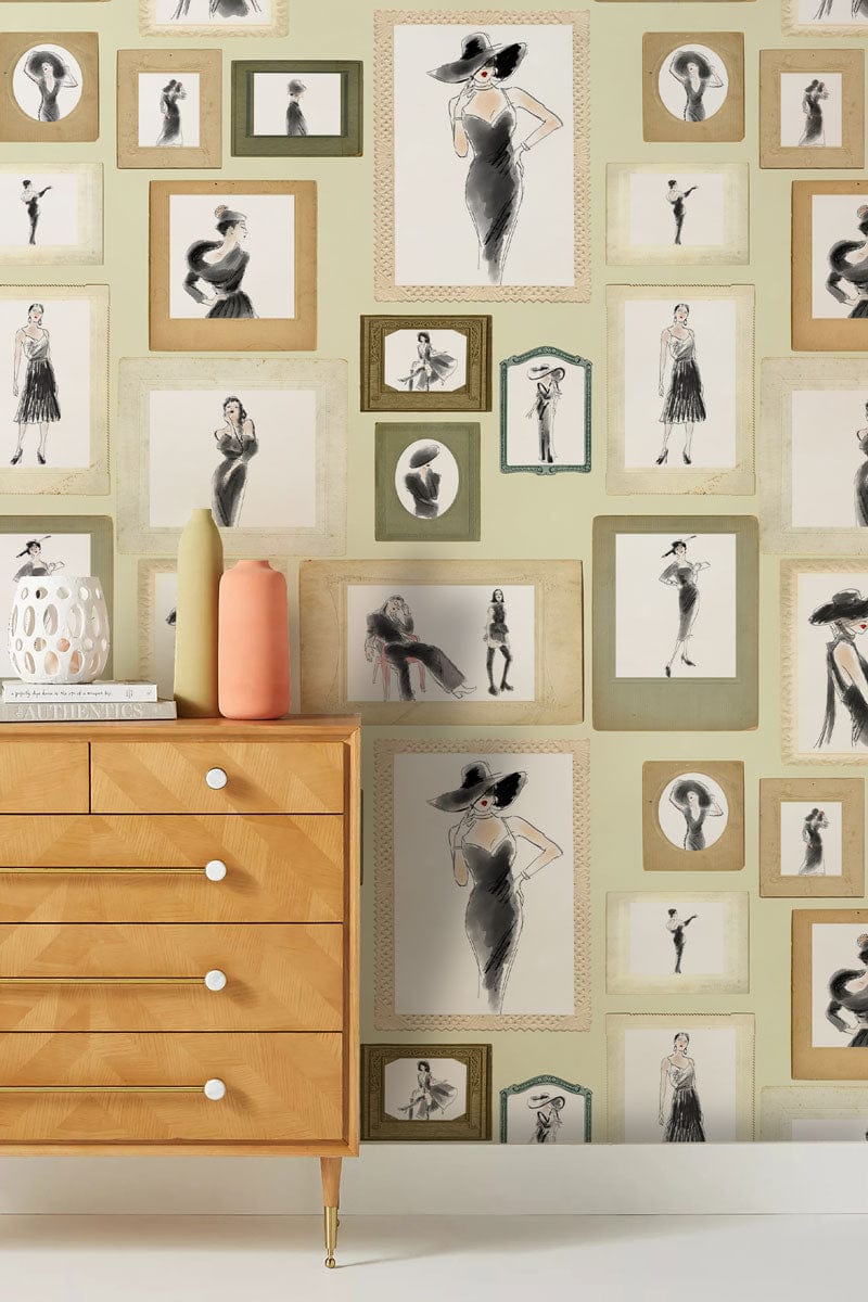 Vintage fashion sketch wallpaper with light wood dresser in stylish room; green and beige decor.