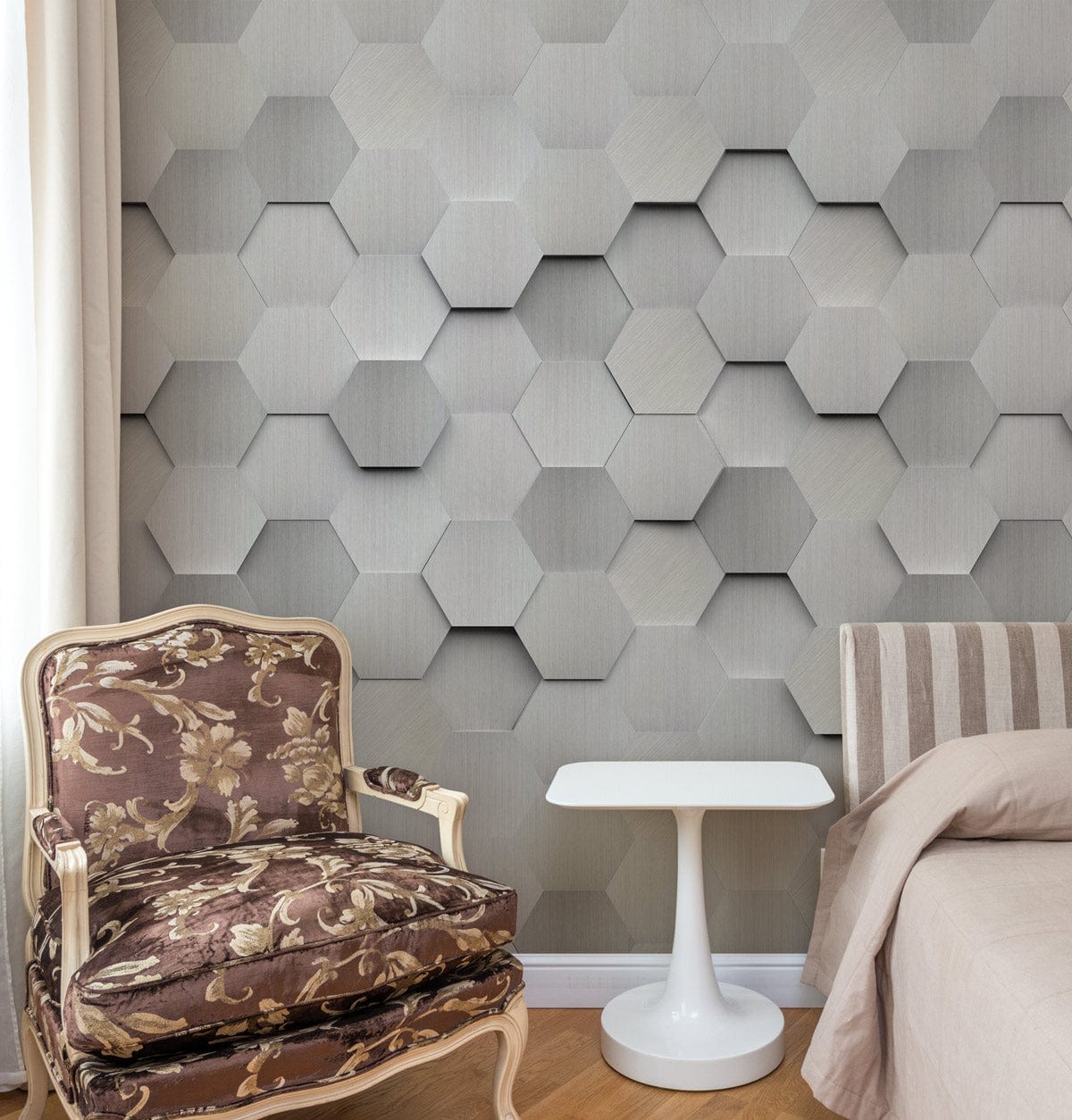 Modern silver hexagonal wallpaper, floral armchair, striped sofa, white table in elegant room setting.