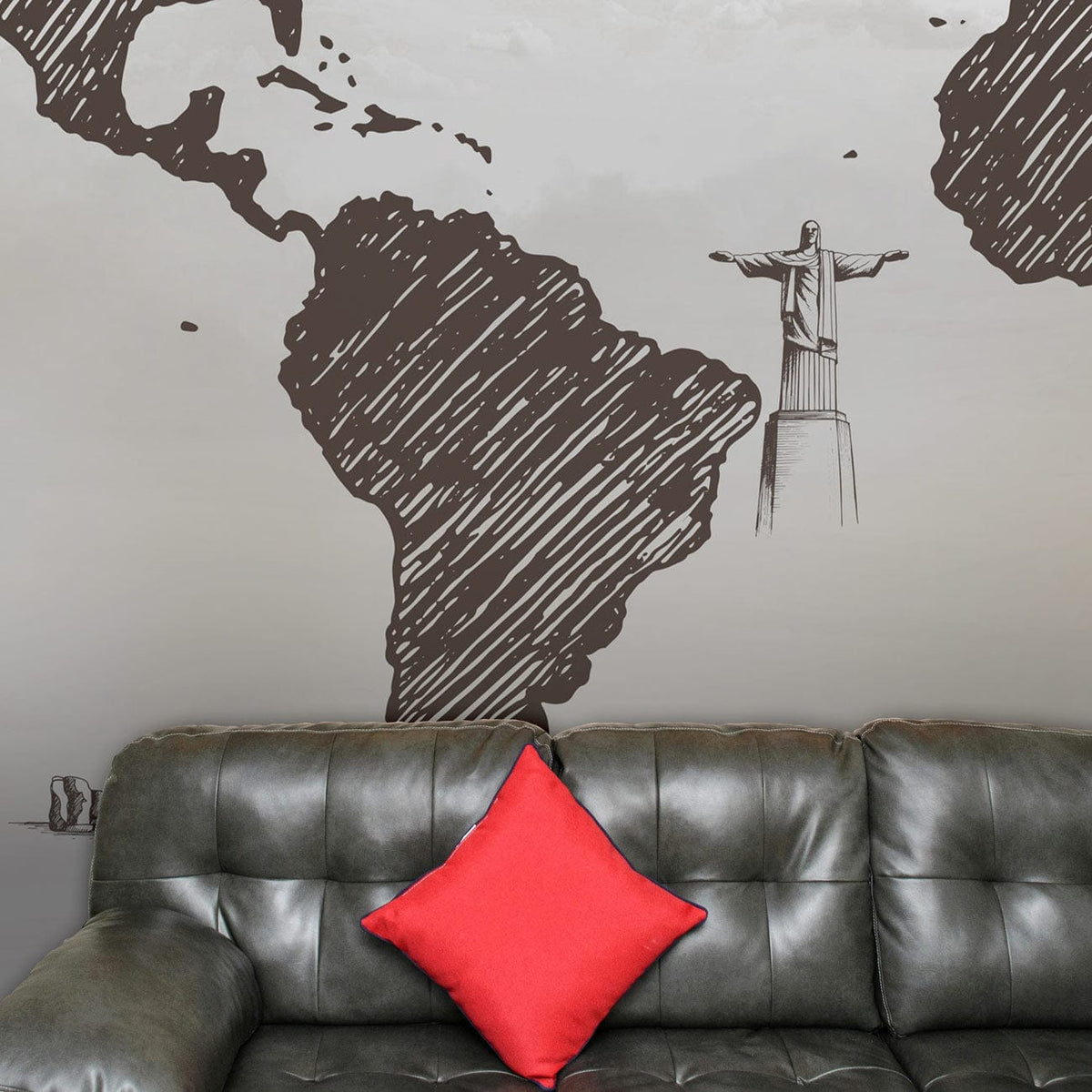 Vintage sketch world map mural wallpaper, charcoal grey, above dark leather sofa, red cushion contrast.
