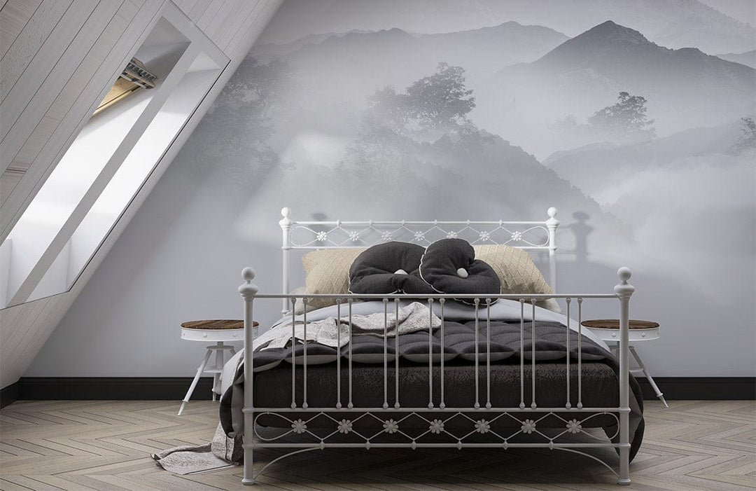 Ethereal Misty Mountain wallpaper behind white bed, attic room with chevron flooring, calming grey tones.