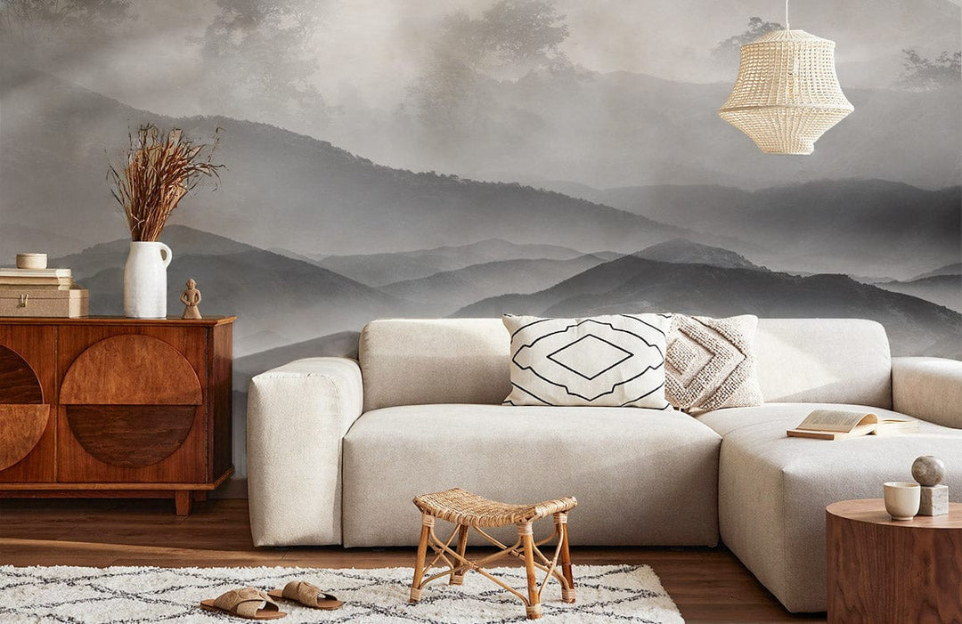 Monochrome grey mountain mural wallpaper with beige sofa, wooden sideboard, pendant light, and geometric rug.