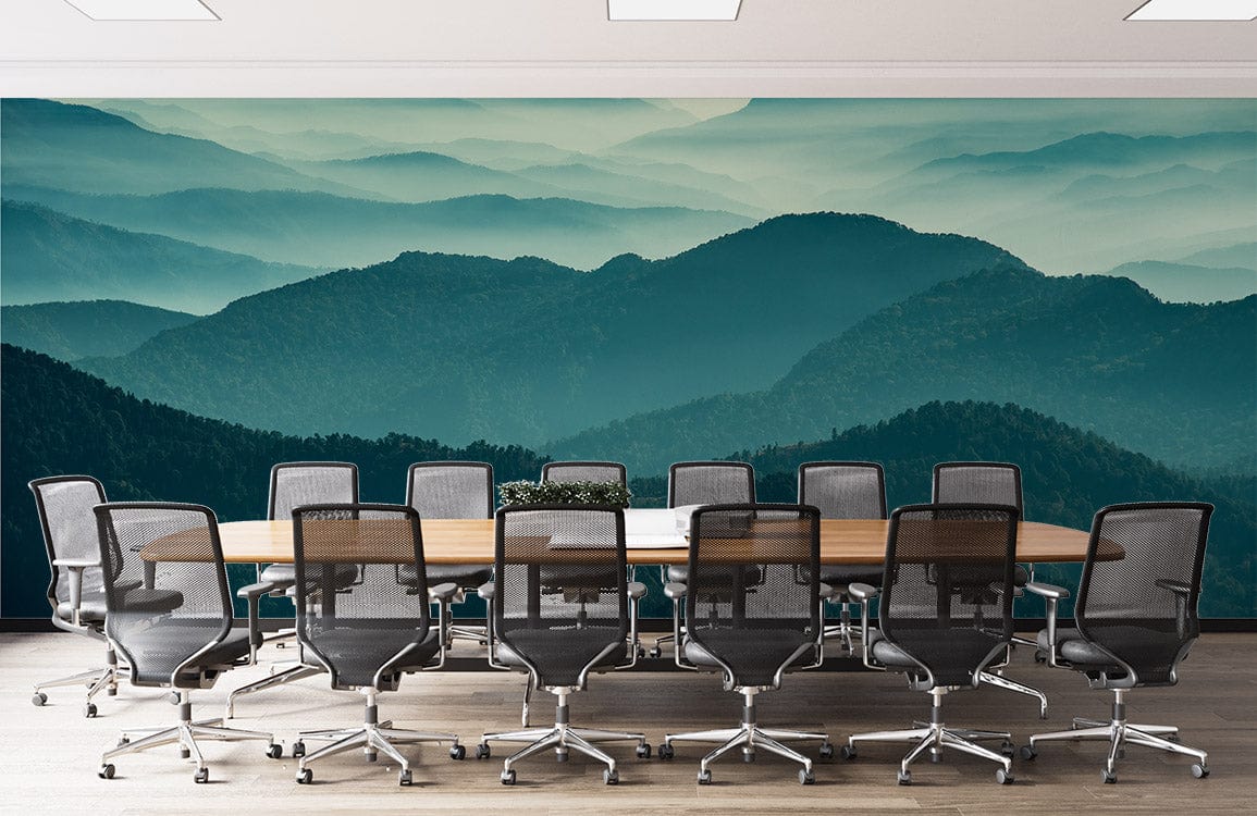 Misty green mountain landscape mural in modern conference room with wooden table, black chairs, grey flooring.