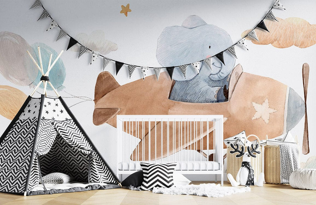 Charming Elephant Adventure Mural Wallpaper in nursery with cot, tipi tent, and wooden flooring.