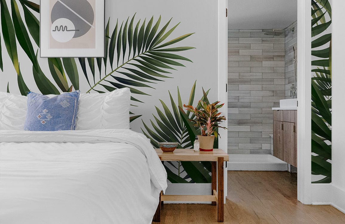 Elegant Green Palm Leaves Tropical Mural Wallpaper enhances modern bedroom with white bedding and wood flooring.