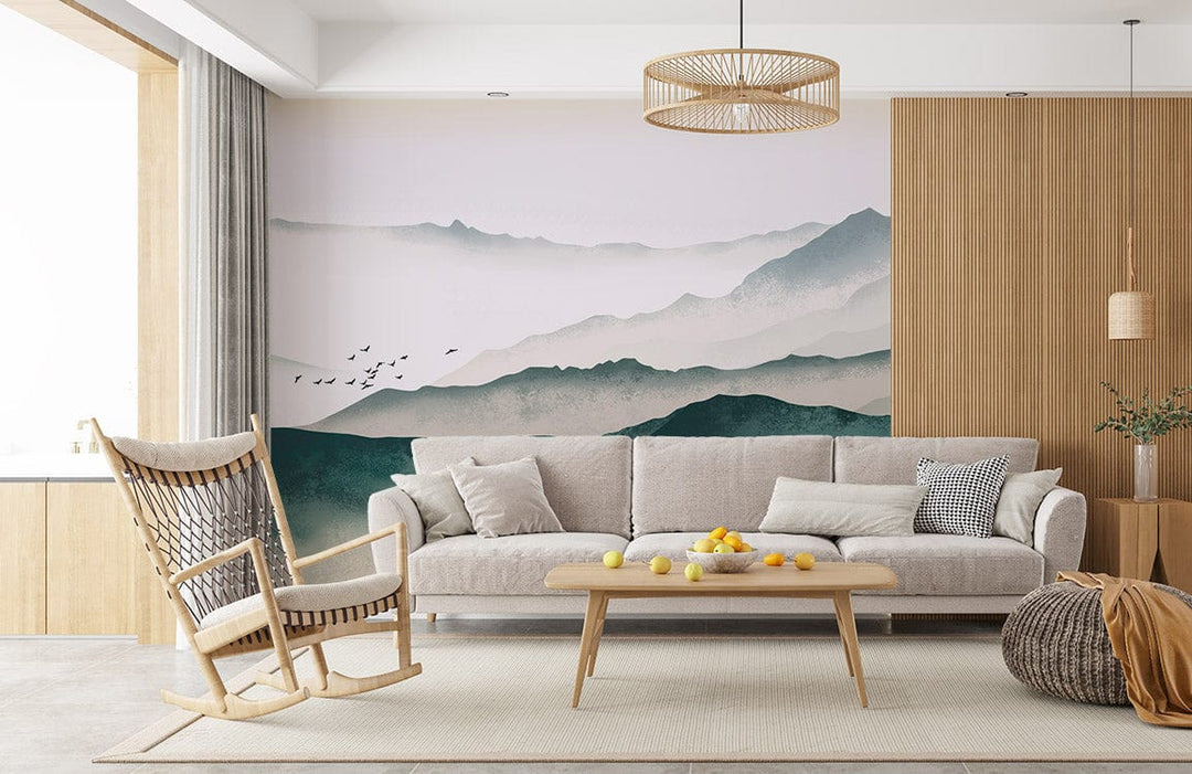 Serene Misty Mountains Mural Wallpaper with grey sofa, wooden chair, beige rug, and pendant light.