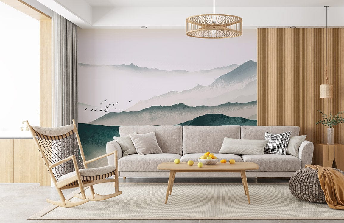 Serene Misty Mountains Mural Wallpaper with grey sofa, wooden chair, beige rug, and pendant light.