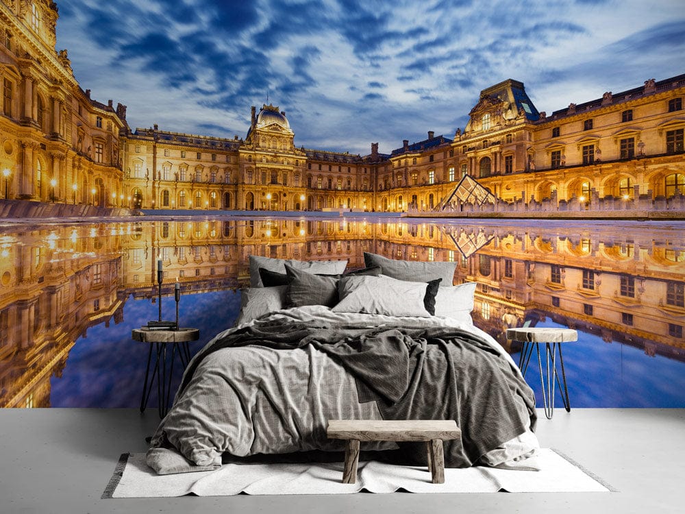 Majestic Paris architecture mural wallpaper, grey bedding, wooden bench, modern side tables, stylish bedroom.