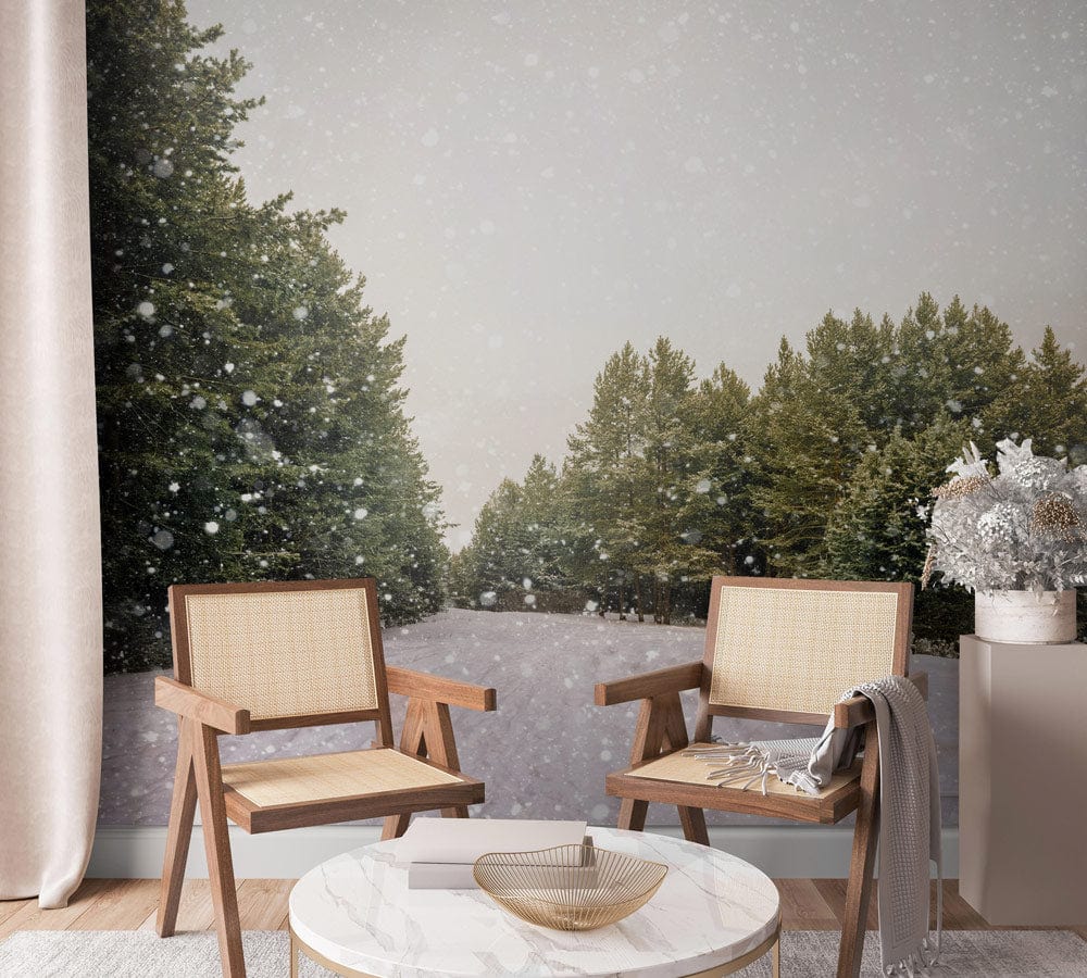 Tranquil wallpaper featuring serene winter forest mural with snow, light brown chairs, round white table.