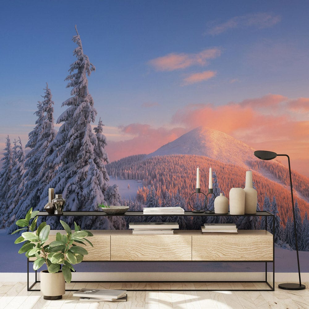 Winter Wonderland mural with sunset glow, snowy pines, modern console table, plant, and floor lamp.