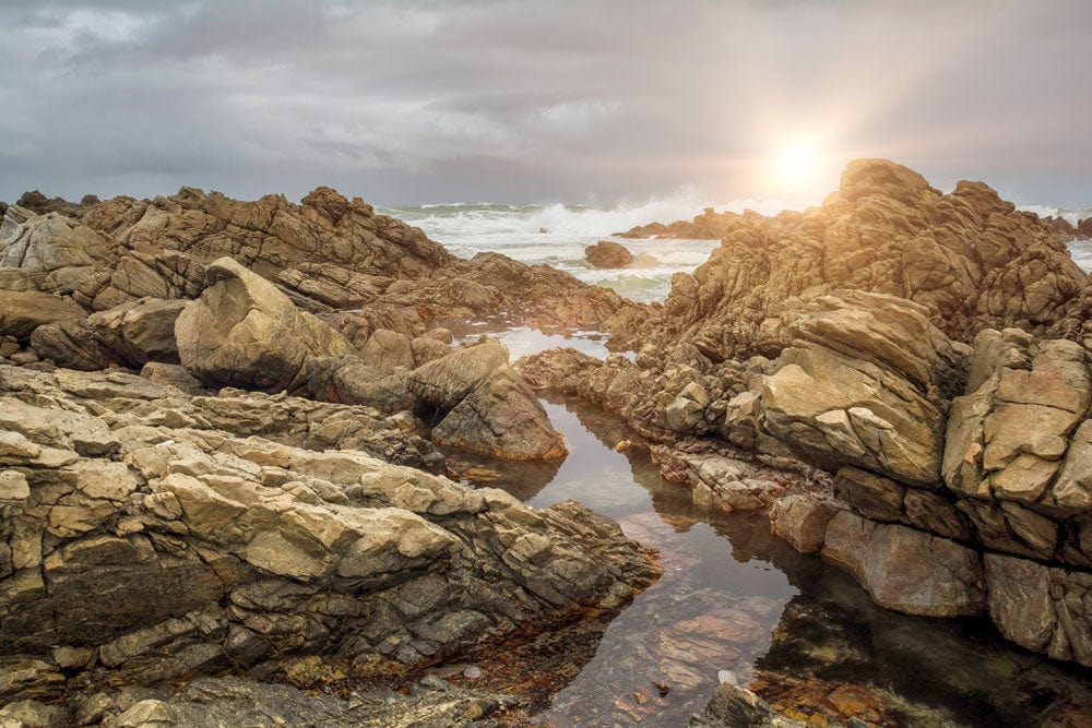 Sunlit Rocky Coastline Mural Wallpaper - Natural Coastal Landscape Design