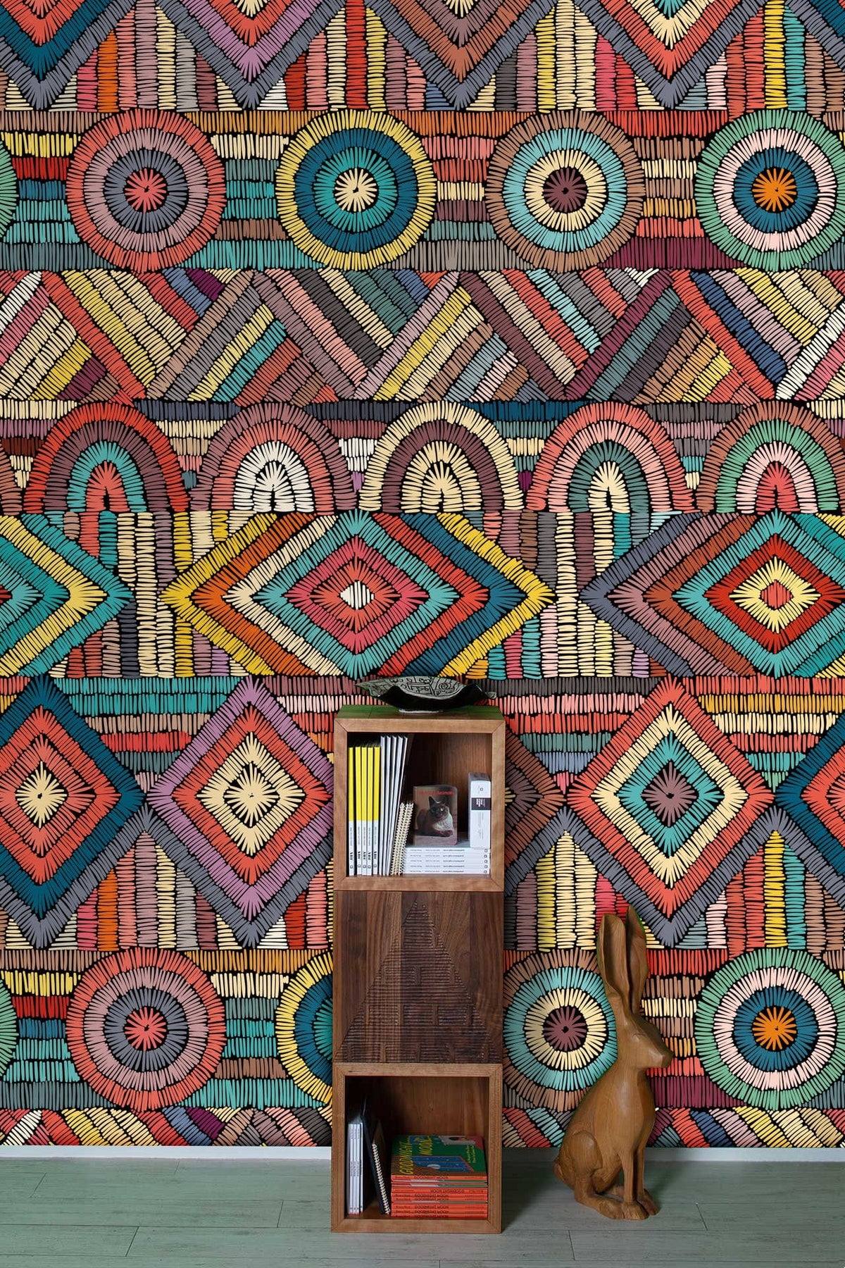Vibrant geometric wallpaper, multicoloured mosaic design, decorative wooden shelving, subtle light green flooring.