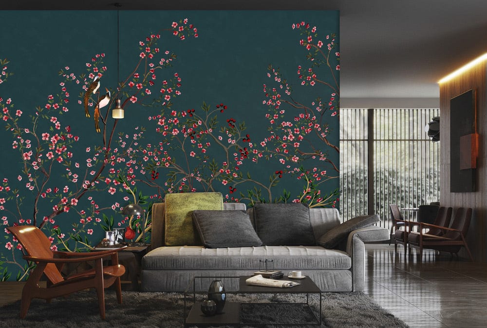 Elegant teal mural wallpaper featuring florals and birds, grey sofa, wooden chairs, in stylish living area.