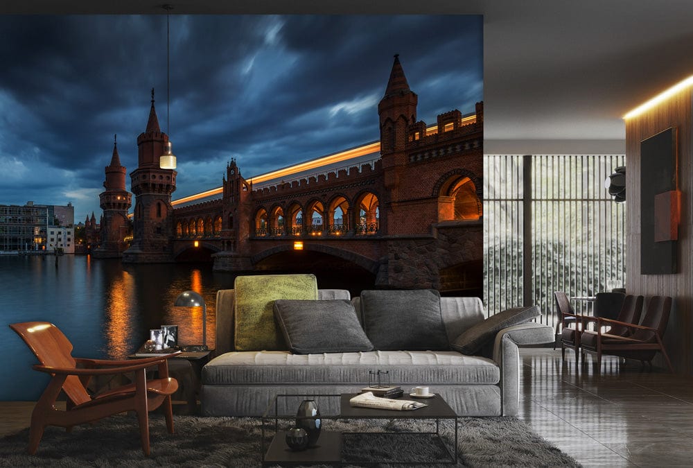 Serene Evening Cityscape Mural Wallpaper, dramatic skies, historic bridge, elegant sofa, modern armchair, rug.