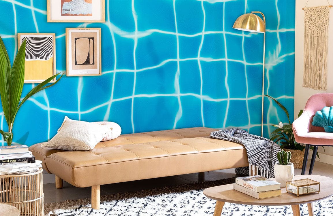 Aqua blue rippling water grid wallpaper in modern living room with tan daybed, pink chair, textured rug.