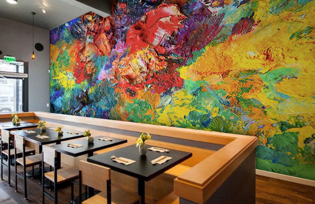 Vibrant abstract mural wallpaper in café with wooden tables, grey walls, and contemporary seating arrangement.
