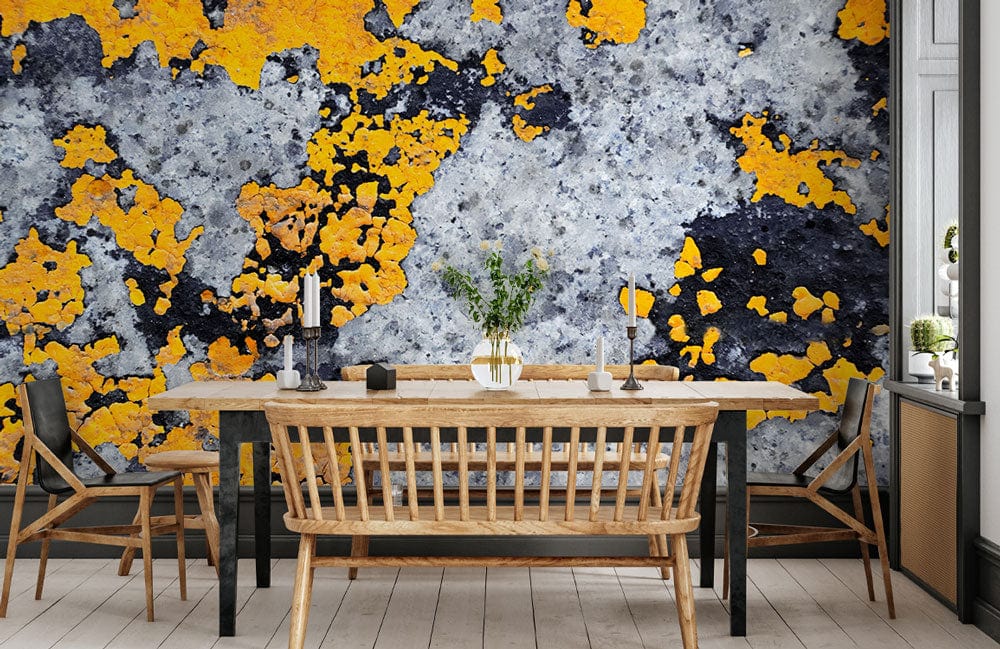 Urban Lichen industrial wallpaper with yellow, grey texture in dining room; wooden chairs, light flooring.
