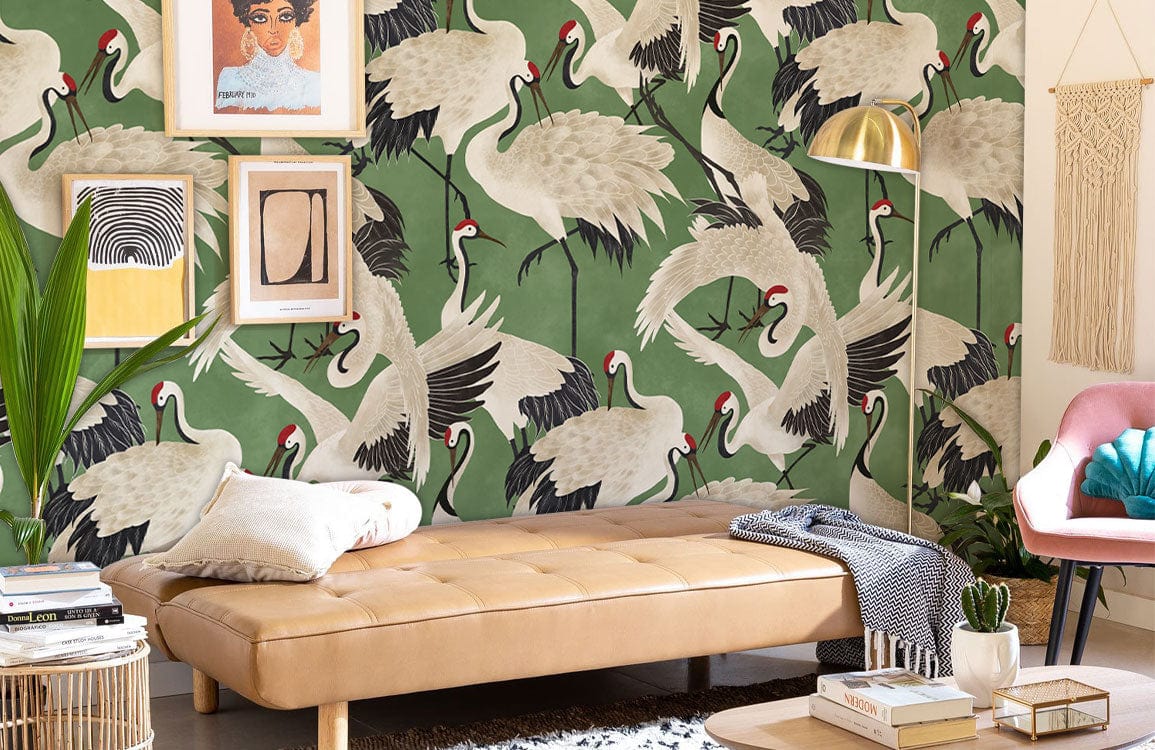 Elegant green crane wallpaper in living room with tan sofa, pink chair, and eclectic artwork.