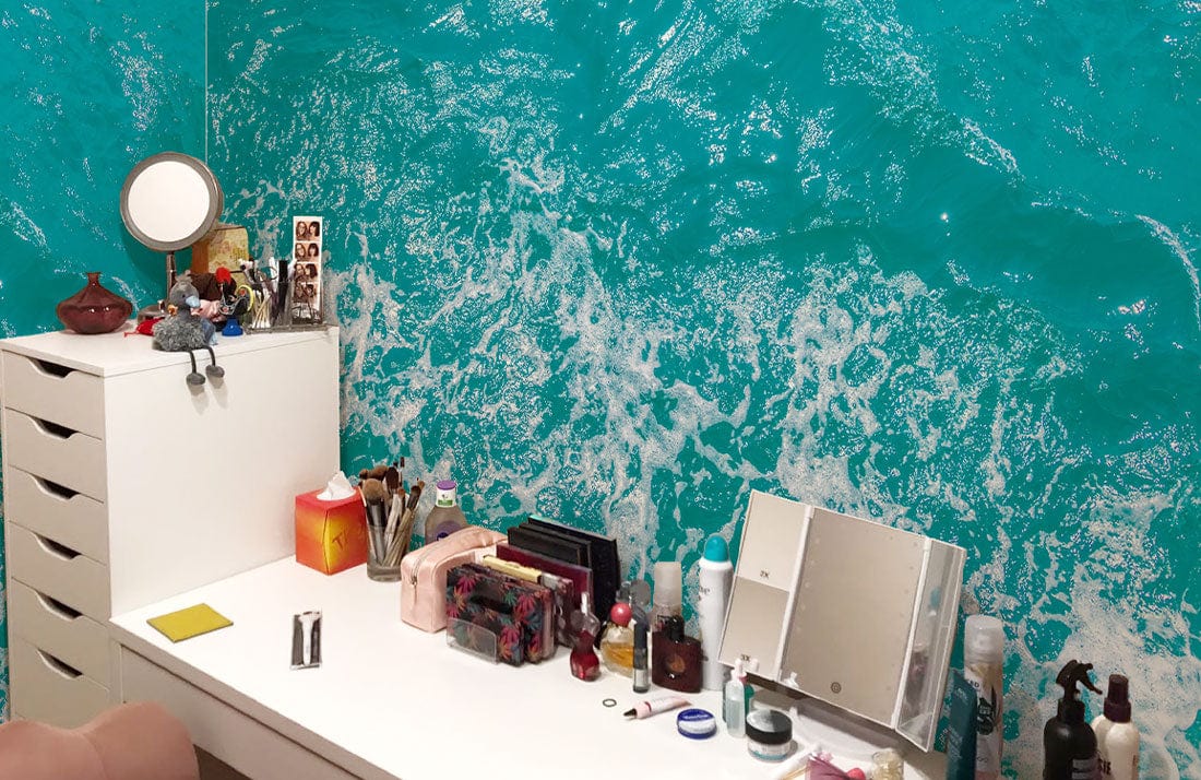 Vanity setup with Turquoise Ocean Waves Mural Wallpaper, in a coastal-themed room, white furniture.
