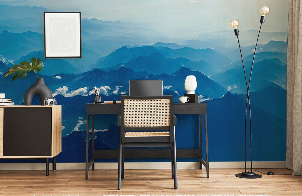 Serene Blue Mountain Mural Wallpaper in study room with black desk, chair, and light wood flooring.