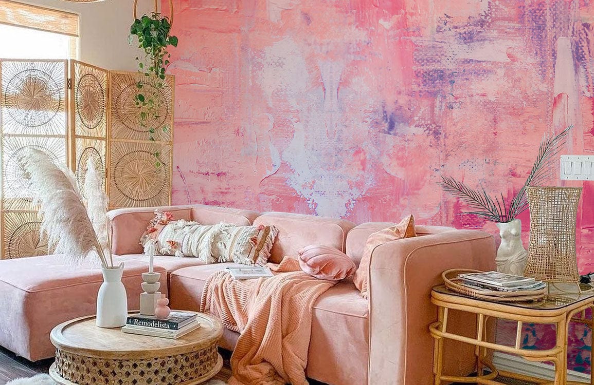 Abstract pastel mural wallpaper complements pink sofa, wicker furniture, wooden accents, and natural decor items.