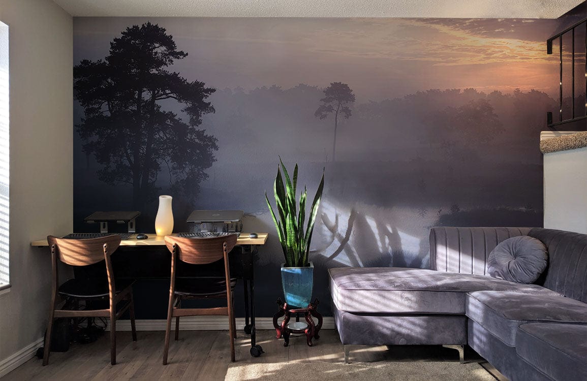 Twilight mist forest wallpaper in blues and purples, grey sectional sofa, wooden chairs, modern decor.