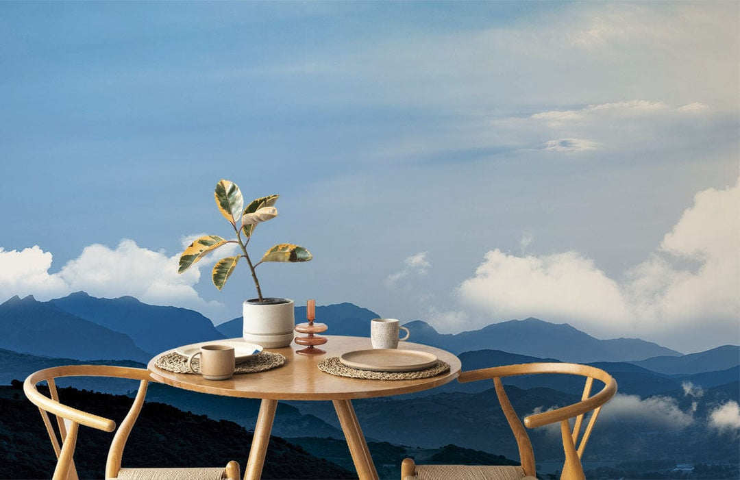 Majestic Blue Mountain Vista mural wallpaper with light wood dining table and chairs, creating serene atmosphere.