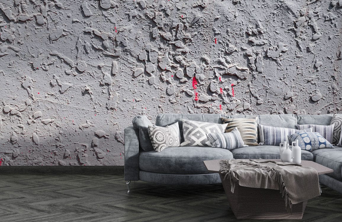 Rustic textured concrete effect wallpaper with subtle red accents, grey curved sofa, patterned flooring, and armchair.