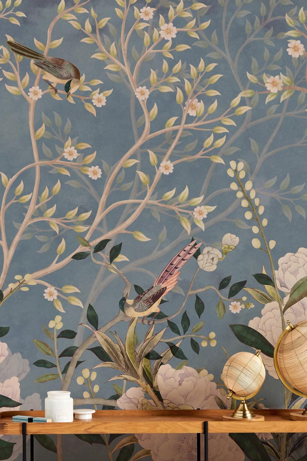 Tranquil Blue Floral Bird Garden Wallpaper decor with elegant wooden table and decorative globes.