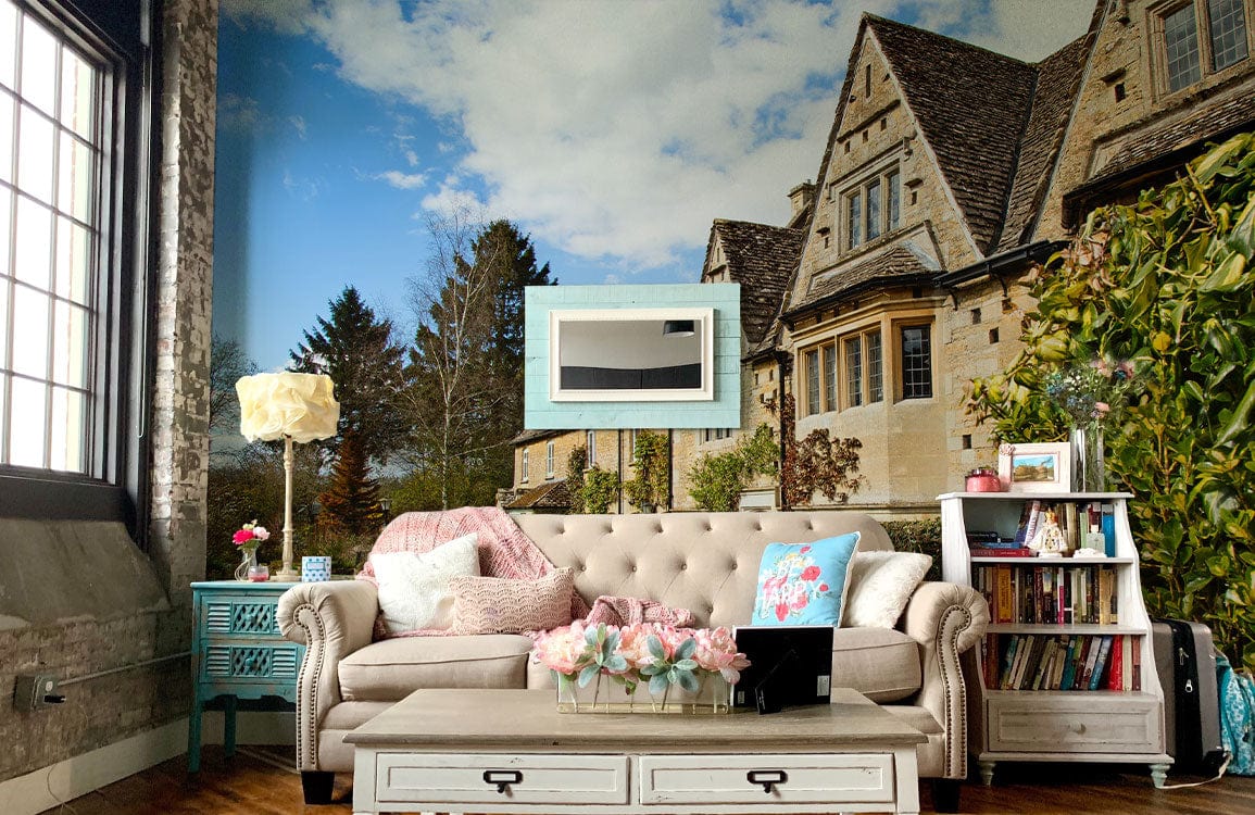 Charming English Countryside Cotswold Cottage Mural Wallpaper, beige sofa, rustic wood flooring, living room decor.