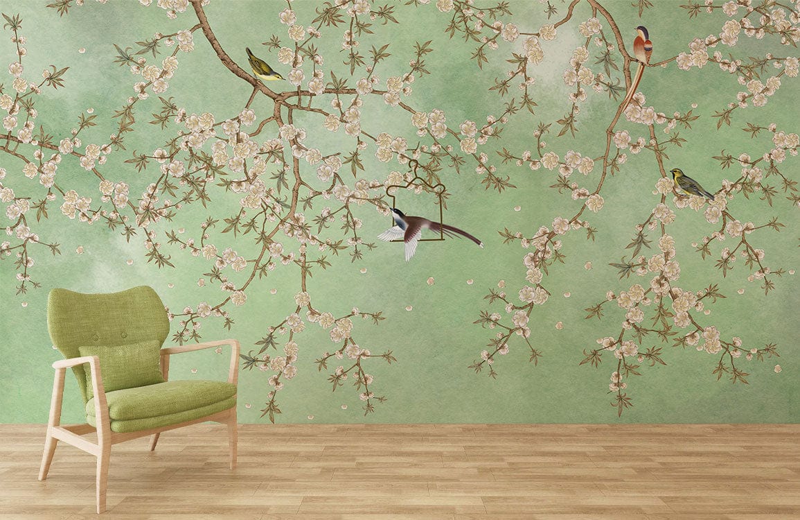 Green Blossom Birds Chinoiserie Mural Wallpaper on living room wall with green chair, wooden flooring.