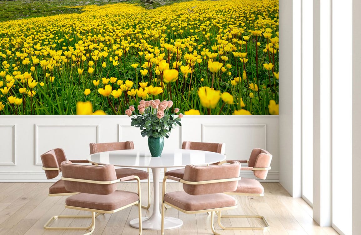 Vibrant yellow wildflower mural wallpaper in dining room with pink chairs, round table, wood flooring.